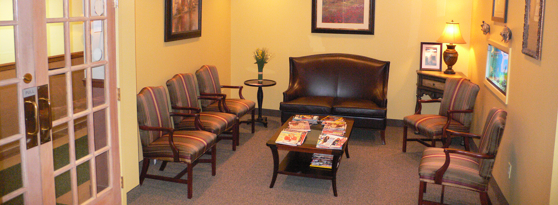 The image shows a modern dental clinic interior with various pieces of equipment, including a dental chair and an X-ray machine.